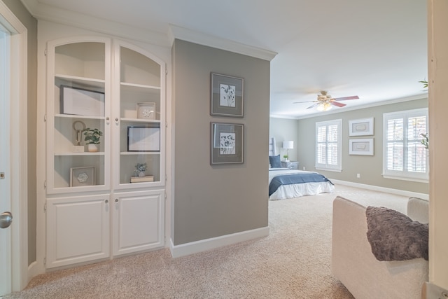 bedroom with light colored carpet, ceiling fan, and ornamental molding