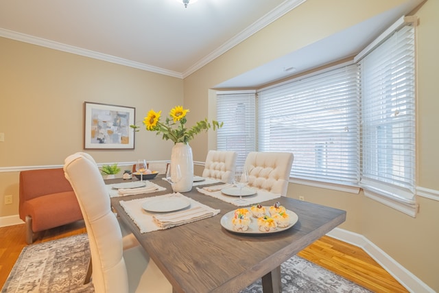 dining space featuring hardwood / wood-style flooring and ornamental molding