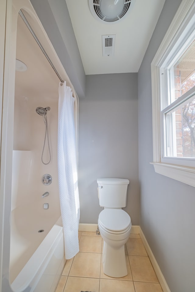 bathroom with tile patterned floors, shower / tub combo with curtain, and toilet