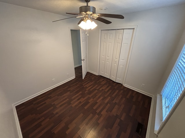 unfurnished bedroom with a closet, ceiling fan, and dark hardwood / wood-style flooring