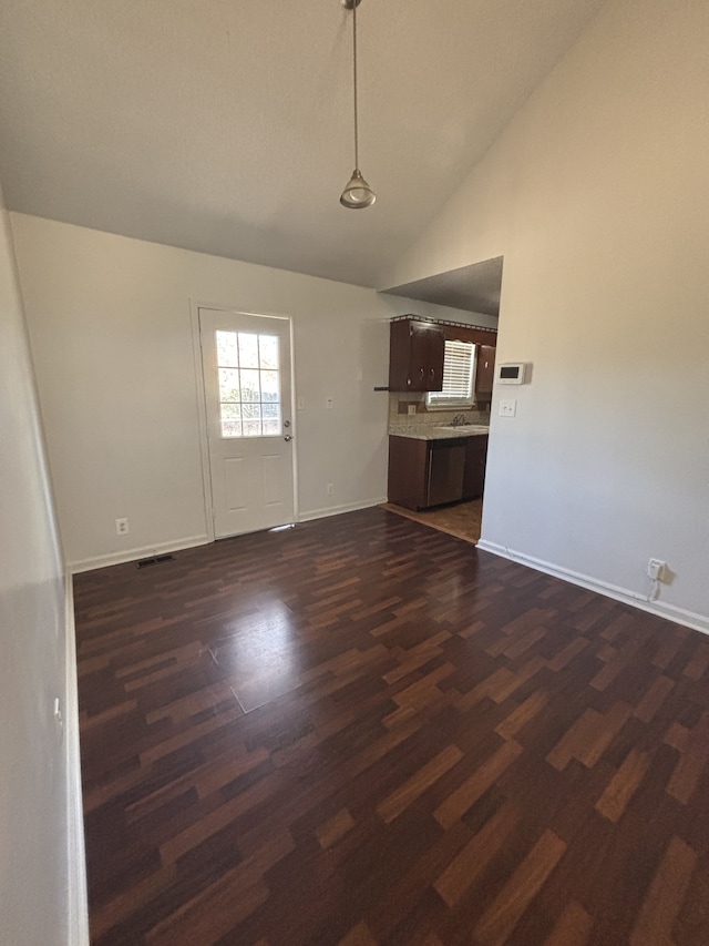 unfurnished living room with sink, dark wood-type flooring, and high vaulted ceiling