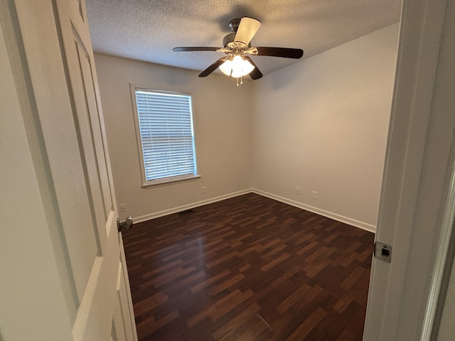 unfurnished room with a textured ceiling, ceiling fan, and dark wood-type flooring