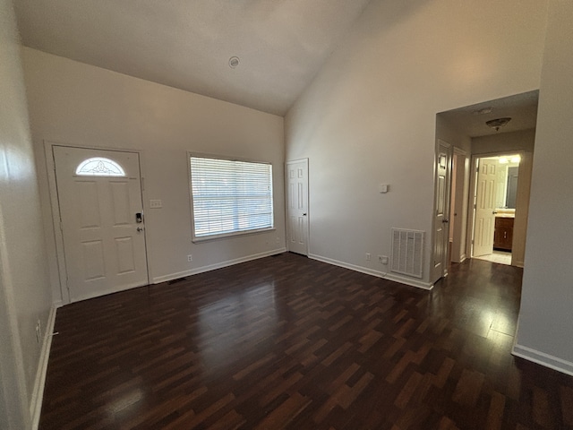 entryway featuring high vaulted ceiling and dark wood-type flooring