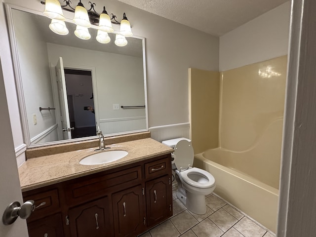 full bathroom featuring tile patterned floors, vanity, a textured ceiling,  shower combination, and toilet