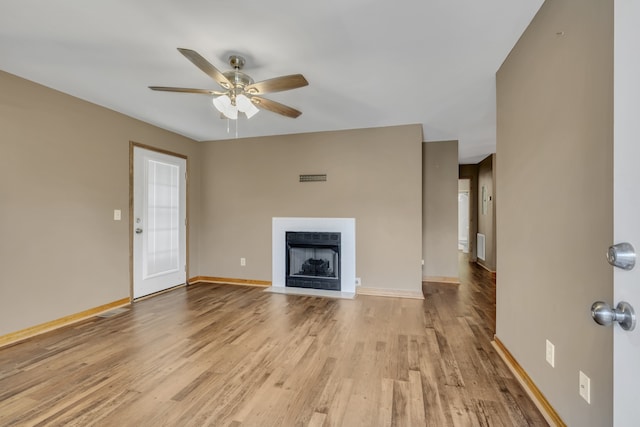 unfurnished living room featuring ceiling fan and light hardwood / wood-style flooring