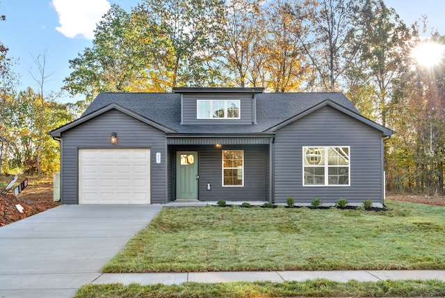 view of front of house with a shingled roof, a front yard, driveway, and an attached garage