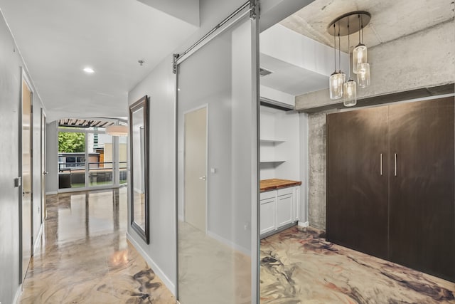 hallway featuring a barn door and built in shelves