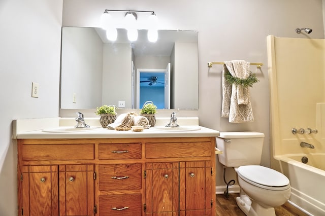 full bathroom featuring hardwood / wood-style floors, vanity, toilet, and shower / tub combination