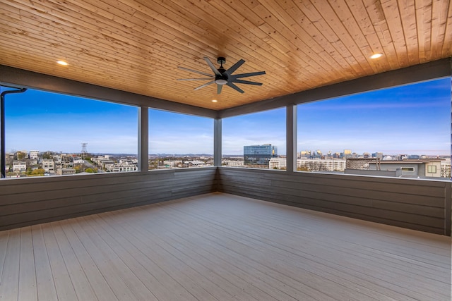 unfurnished sunroom with ceiling fan and wooden ceiling