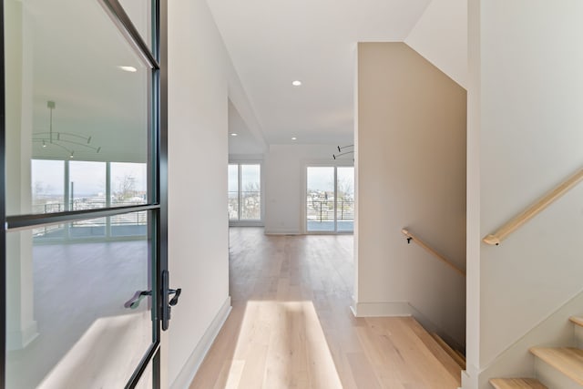 hallway with expansive windows and light wood-type flooring