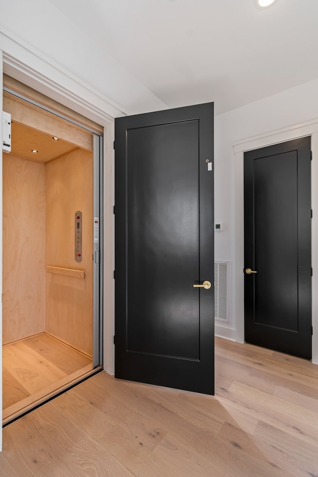 interior space with light hardwood / wood-style floors and elevator