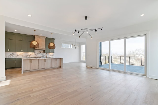 unfurnished living room with light hardwood / wood-style floors and a chandelier