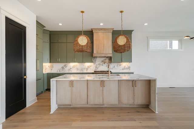 kitchen with light stone countertops, pendant lighting, and light hardwood / wood-style flooring