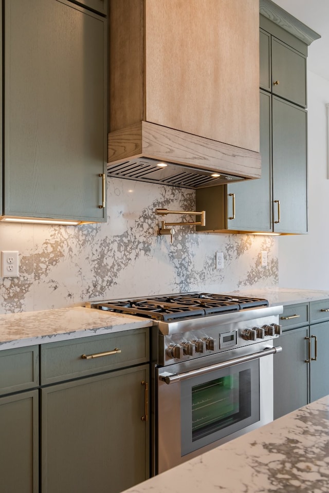 kitchen featuring green cabinetry, high end range, custom exhaust hood, and tasteful backsplash