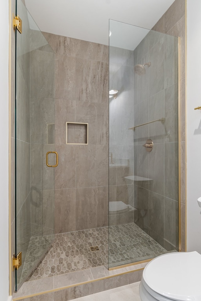 bathroom with a shower with shower door and toilet