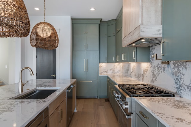 kitchen with light stone countertops, sink, stainless steel appliances, premium range hood, and light wood-type flooring