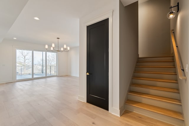 stairway with a chandelier and wood-type flooring