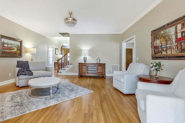 living room with light hardwood / wood-style floors and crown molding