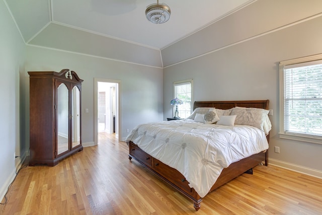 bedroom featuring vaulted ceiling, light hardwood / wood-style flooring, and crown molding