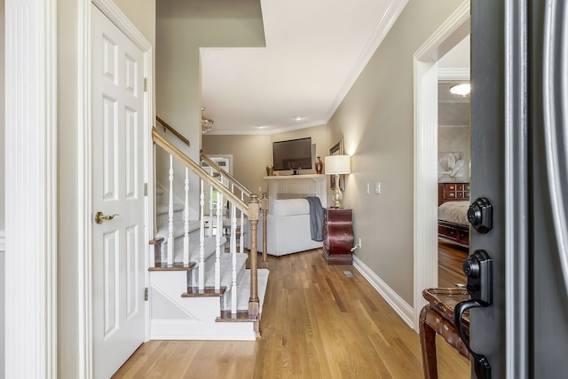 entryway with light hardwood / wood-style flooring and ornamental molding