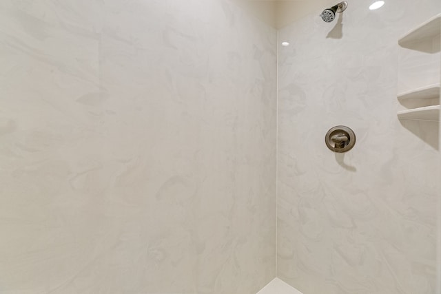 interior details featuring tiled shower