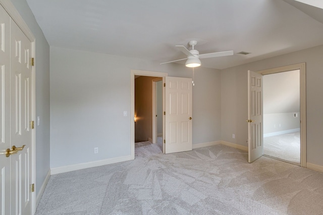 unfurnished bedroom featuring ceiling fan, light carpet, and a closet