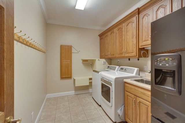 laundry area featuring washer and clothes dryer, light tile patterned flooring, cabinets, and crown molding