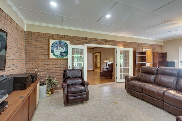 living room with light hardwood / wood-style floors, french doors, brick wall, and ornamental molding