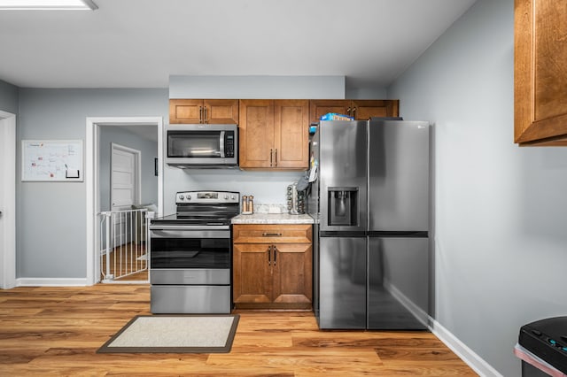 kitchen with stainless steel appliances and light hardwood / wood-style flooring