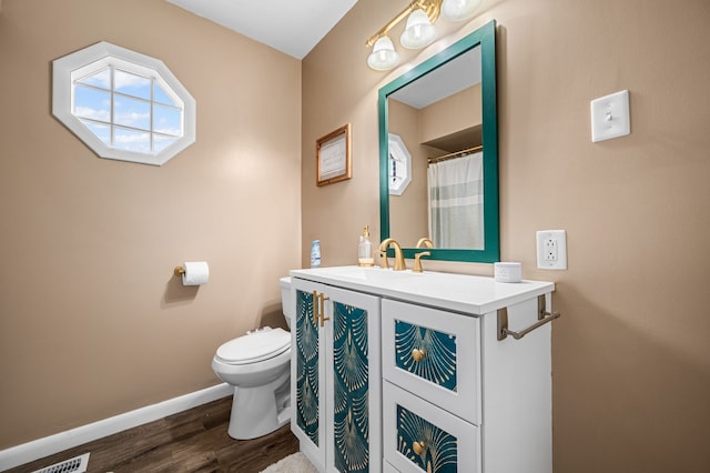 bathroom featuring toilet, vanity, and hardwood / wood-style flooring