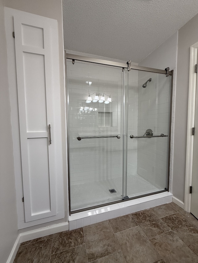 bathroom featuring a textured ceiling and an enclosed shower