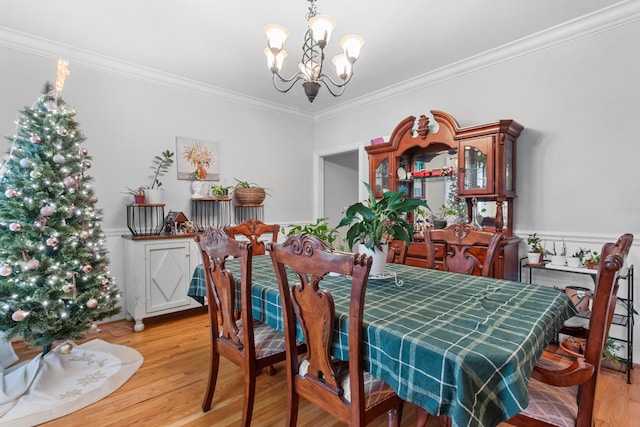 dining room with an inviting chandelier, light hardwood / wood-style flooring, and ornamental molding