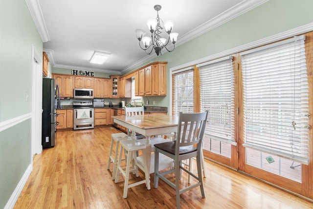 dining area with light wood-type flooring, crown molding, and a healthy amount of sunlight