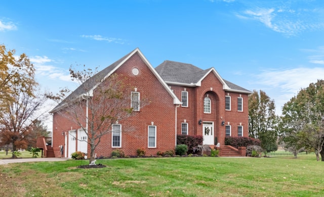 colonial-style house featuring a garage and a front lawn