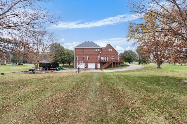 back of property with a lawn, a wooden deck, and a garage