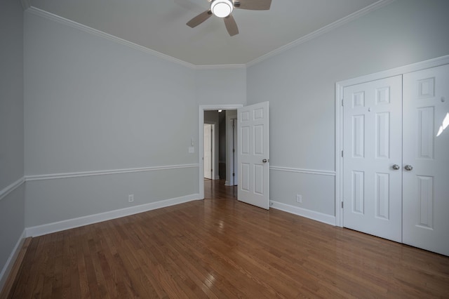 unfurnished bedroom featuring ceiling fan, dark hardwood / wood-style flooring, ornamental molding, and a closet