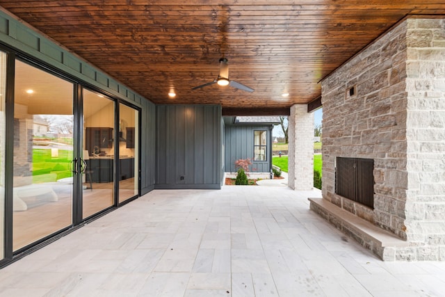 view of patio with an outdoor stone fireplace and ceiling fan