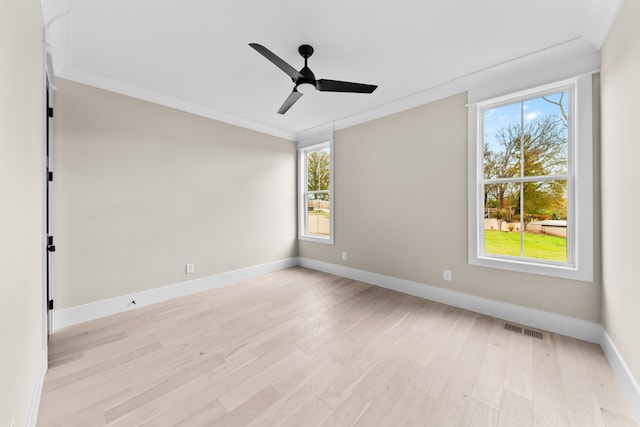 spare room with plenty of natural light, light hardwood / wood-style floors, and ornamental molding