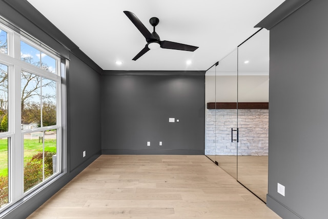 interior space featuring ceiling fan, plenty of natural light, light hardwood / wood-style floors, and ornamental molding