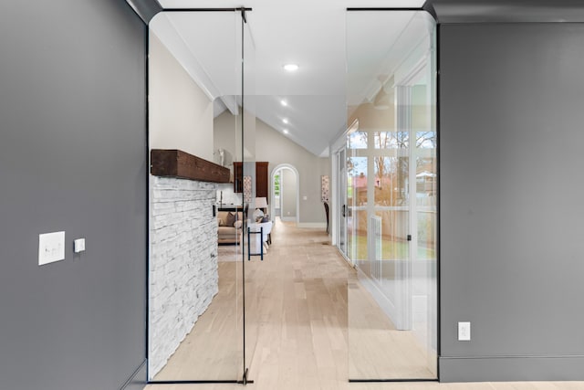 hall with light hardwood / wood-style flooring and lofted ceiling