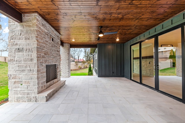 view of patio featuring an outdoor stone fireplace and ceiling fan