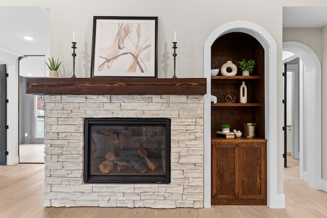 interior details featuring hardwood / wood-style flooring and a stone fireplace