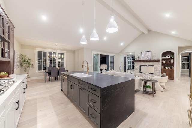 kitchen with sink, white cabinets, decorative light fixtures, and light hardwood / wood-style flooring