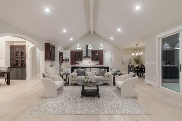 living room with beamed ceiling, high vaulted ceiling, light hardwood / wood-style flooring, and a notable chandelier