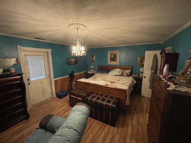 bedroom featuring crown molding, hardwood / wood-style floors, and a textured ceiling