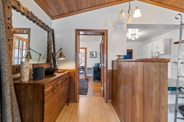 interior space featuring lofted ceiling, wooden ceiling, hanging light fixtures, light wood-type flooring, and white cabinetry