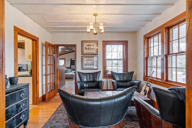 sitting room featuring light hardwood / wood-style flooring, french doors, and a notable chandelier