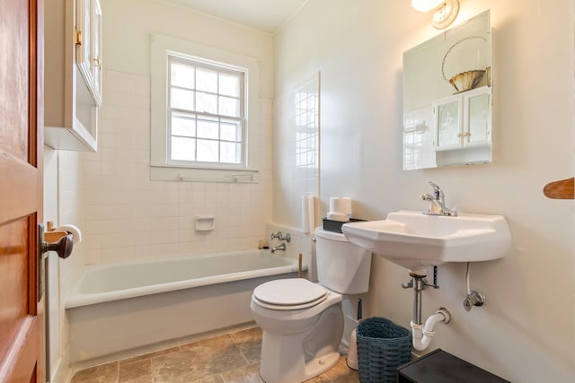 bathroom with a washtub and toilet