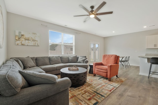 living room featuring ceiling fan and light wood-type flooring