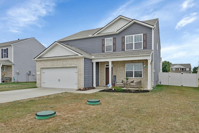 view of front of property featuring covered porch, a garage, and a front yard